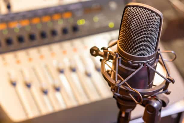 condenser microphone on mixing console background. audio recording concept